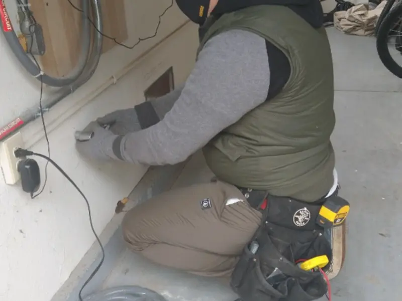 Electrician performing outlet wiring in a Southside garage